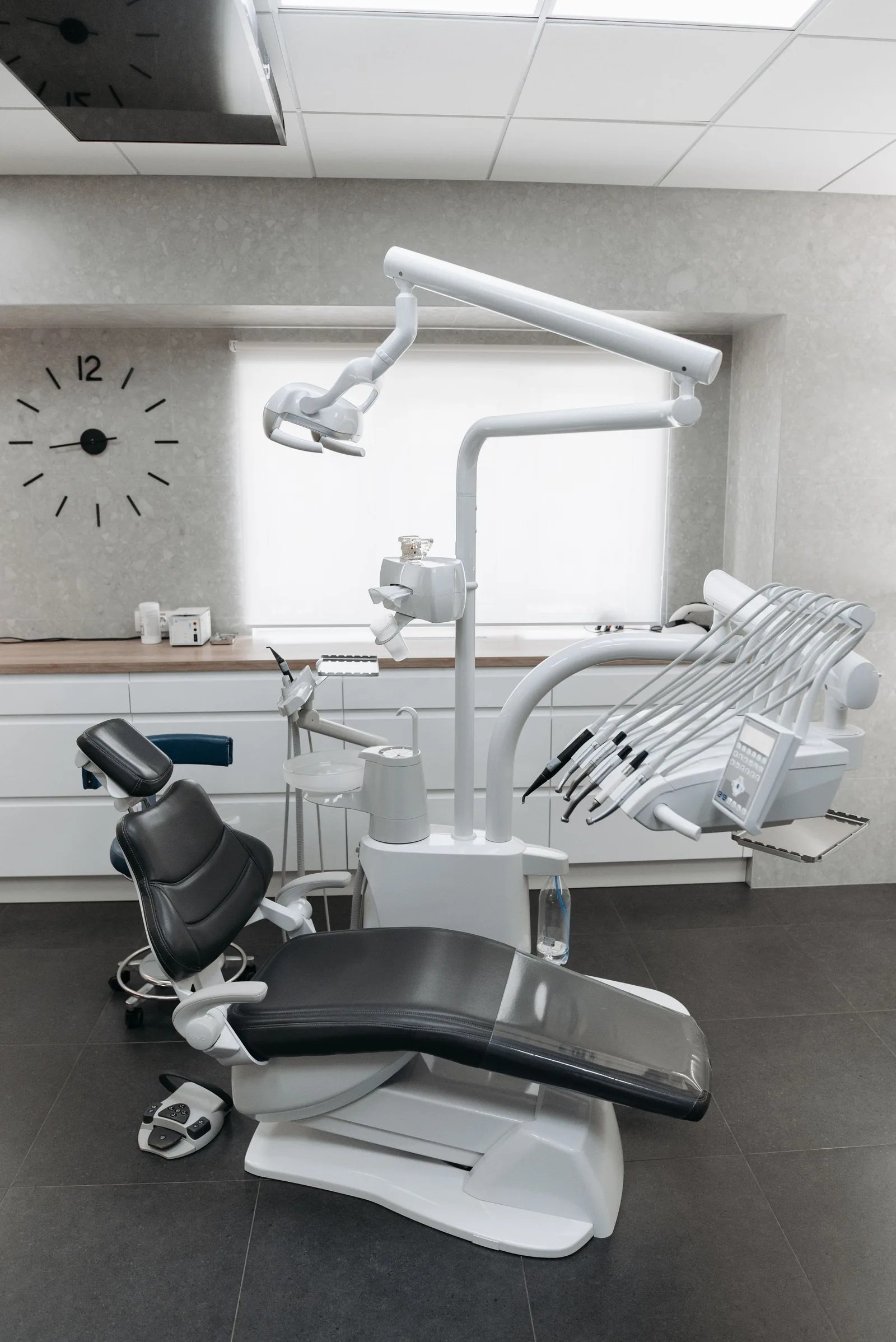 Bright treatment room with a dental chair by the window